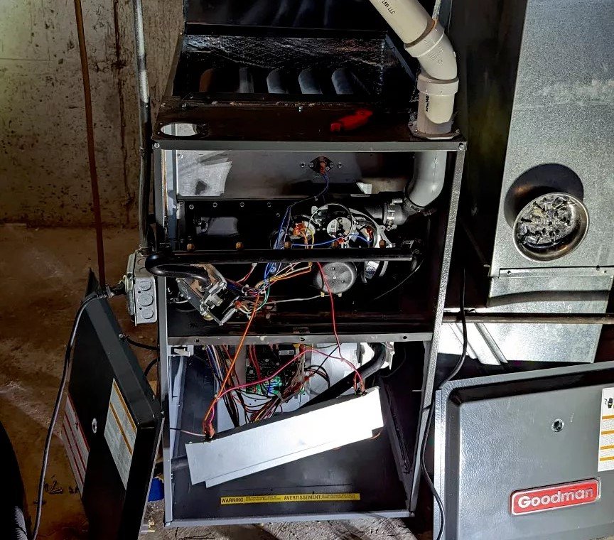 Interior view of a Goodman furnace with wiring exposed, showing detailed repair work for heating services in Boston, MA.